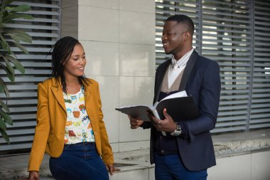 Mutlu iş adamları, resmi giyinmiş kadın ve erkek bir iş planı ya da açık hava projesini incelerken ayakta duruyorlar. konsept toplantısı ve ortaklık