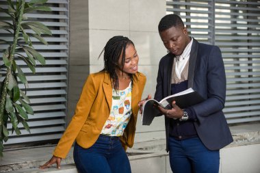 Mutlu iş adamları, resmi giyinmiş kadın ve erkek bir iş planı ya da açık hava projesini incelerken ayakta duruyorlar. konsept toplantısı ve ortaklık