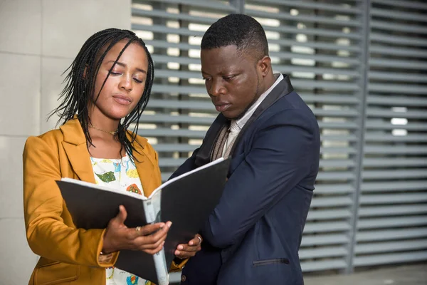 Mutlu iş adamları, resmi giyinmiş kadın ve erkek bir iş planı ya da açık hava projesini incelerken ayakta duruyorlar. konsept toplantısı ve ortaklık