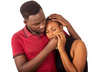 Genç adam üzgün kız arkadaşını teselli etmek için ayakta duruyor..