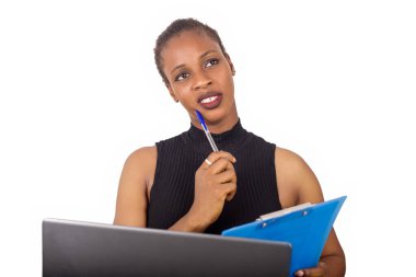 Genç kendine güvenen sekreter ya da ofis müdürü ofisinin önünde oturuyor ve iş planını laptopunun önünde yazıyor.