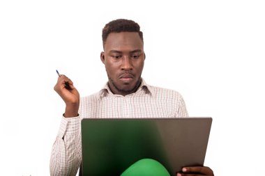 Genç adam bir sandalyede oturmuş laptopa bakıyor..