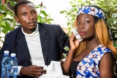 Kafedeki oldukça romantik bir çift. Genç bir kadın yaz mevsiminde erkek arkadaşıyla masada otururken şiddetli sıcaktan muzdarip: bir kadın bir paket mendille terini alnına siliyor.