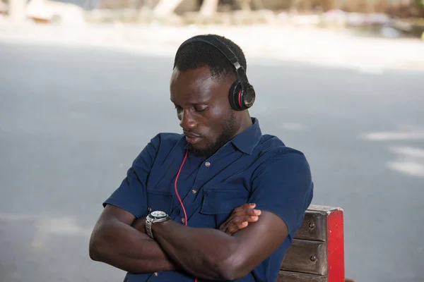 Genç Adam Dışarıda Oturup Kulaklıkla Müzik Dinliyor — Stok fotoğraf