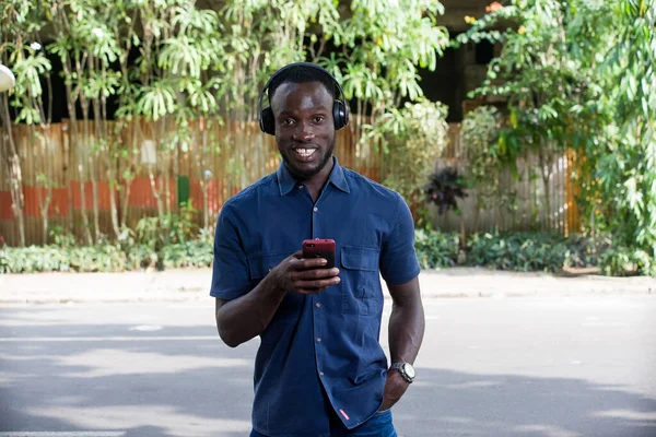 Homem Ouve Música Com Fones Ouvido Usando Telefone Celular Livre — Fotografia de Stock