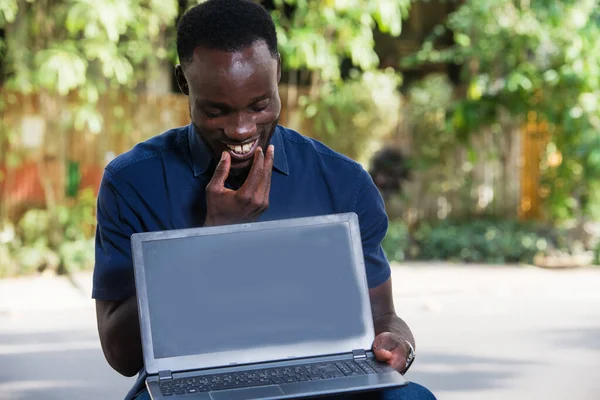 Jovem Sentado Livre Olhando Para Laptop Enquanto Sorri — Fotografia de Stock