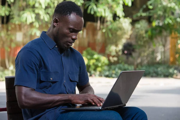 Młody Człowiek Siedzi Zewnątrz Patrząc Laptopa Niezadowoleniem — Zdjęcie stockowe