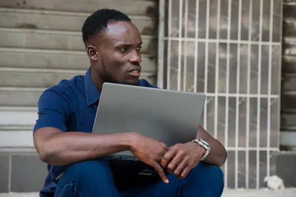 Młody Człowiek Siedzi Podłodze Laptopem Patrząc Profilu — Zdjęcie stockowe