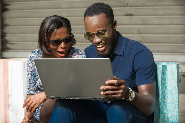 Joven Pareja Sentado Gafas Sol Mirando Portátil Riendo —  Fotos de Stock