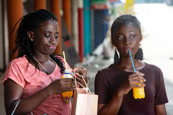 Νεαρά Κορίτσια Που Στέκονται Εξωτερικούς Χώρους Πίνοντας Χυμό Φρούτων Τσάντες — Φωτογραφία Αρχείου