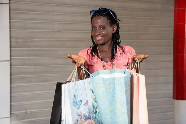 Joven Mujer Pie Afuera Con Gafas Sol Presentando Bolsas Compras —  Fotos de Stock