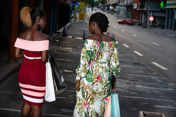 Elbise Giymiş Genç Kadınlar Ellerinde Alışveriş Torbalarıyla Yürüyorlar — Stok fotoğraf