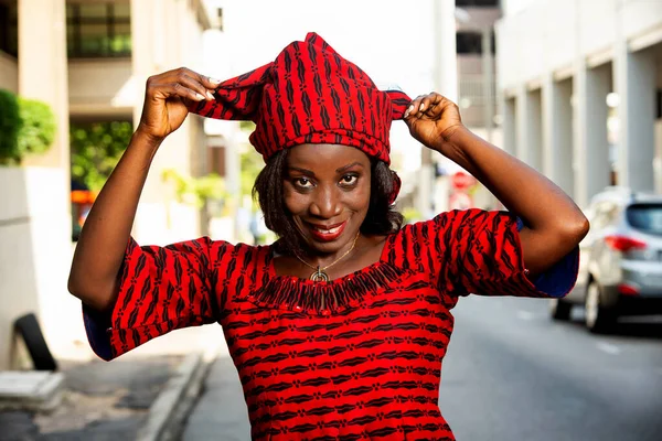 Зрелая Африканская Женщина Стоит Улице Регулируя Свой Шарф Глядя Камеру — стоковое фото