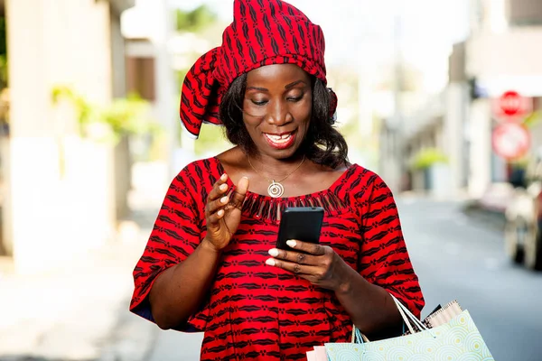 Зрелая Женщина Набедренной Повязке Стоит Улице Смотрит Мобильный Телефон Улыбаясь — стоковое фото