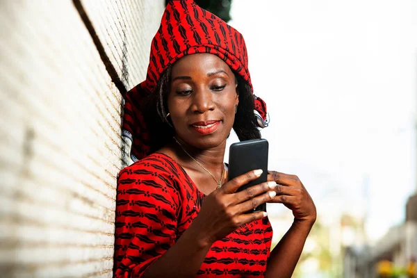 Beautiful Adult Woman Red Loincloth Standing Wall Looking Her Mobile — Stock Photo, Image