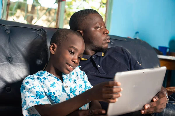 Mladý Afričan Sedí Křesle Pohledným Chlapečkem Držícím Ruce Digitální Tablet — Stock fotografie