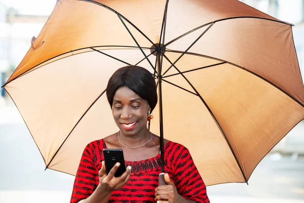 Зрелая Женщина Традиционной Одежде Стоит Смотрит Мобильный Телефон Улыбаясь Зонтиком — стоковое фото