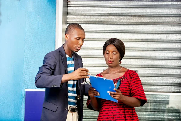 Gutaussehende Afrikanische Geschäftsfrau Und Geschäftsfrau Betrachten Gemeinsam Ein Dokument Freien — Stockfoto