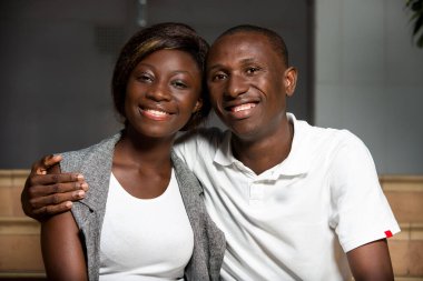 Gülümseyen adam ve kadın merdivenlerde oturmuş konuşuyor. Genç Afro-Amerikan erkek ve Asyalı kadın merdivenlerde birlikte oturuyor. Çift veya arkadaş kavramı