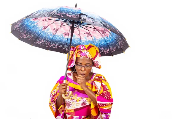 mature beautiful woman in traditional outfit standing on white background holding umbrella while coughing.