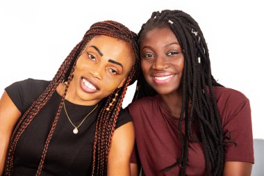 İki güzel kız kardeş yan yana oturmuş gülümsüyor.