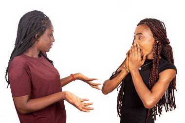 Biri kırmızı bir bordo tişört giyip ellerini sallarken diğeri de siyah elbiseli elleriyle ağzını kapatıyor..