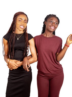 İki güzel kız yan yana durmuş, sırıtıyorlar.