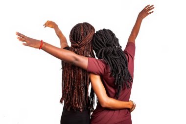 Uzun örgülü iki güzel kız arkada duruyor.