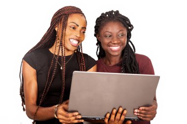 İki gülümseyen güzel kız kardeş koyu siyah ve kırmızı renklerde dizüstü bilgisayar tutuyorlar.