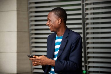 İzole edilmiş bir sokakta cep telefonu kullanan mutlu bir adamın yan görünümü