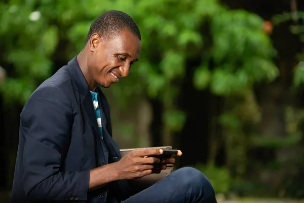 Африканский Бизнесмен Сидящий Саду Пиджаке Разговаривая Телефону Такое — стоковое фото