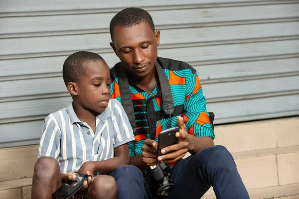 Jóképű Fiatal Apa Fiával Apa Képeket Mutat Fiának Mobiltelefonon Utcán — Stock Fotó