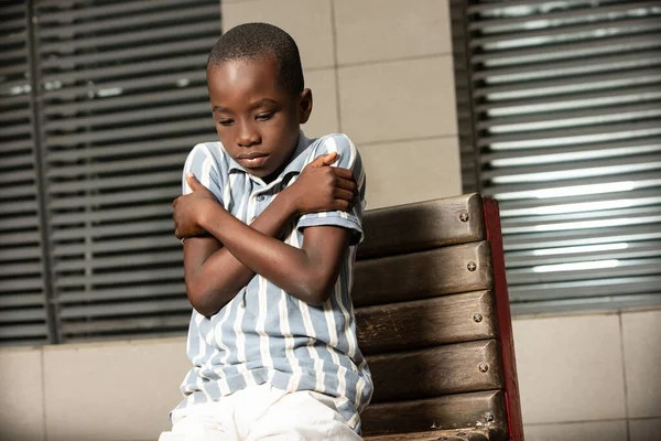 Klein Afrikaans Jongetje Zittend Een Bankje Met Kou Gebaar Schudden — Stockfoto