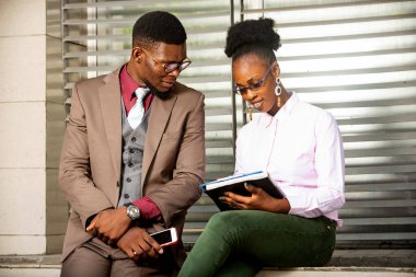 İş adamı, sekreteriyle konuşurken o da dışarıdan not alıyordu.