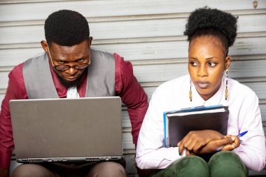 Profesyonel bir sunum sırasında iş tartışan iki genç işadamı