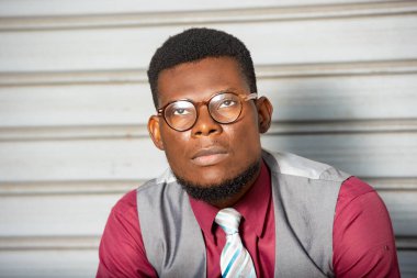 ciddi genç iş adamı gözlüklü oturuyor ve yukarı bakıyor.