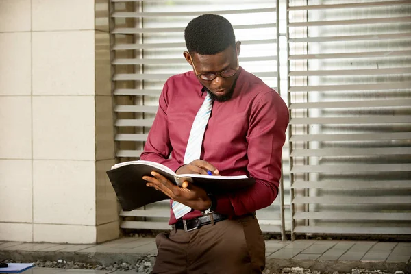 Africký Podnikatel Podívá Svého Kancelářského Zápisníku Sobě Bordeaux Červený Kašmír — Stock fotografie