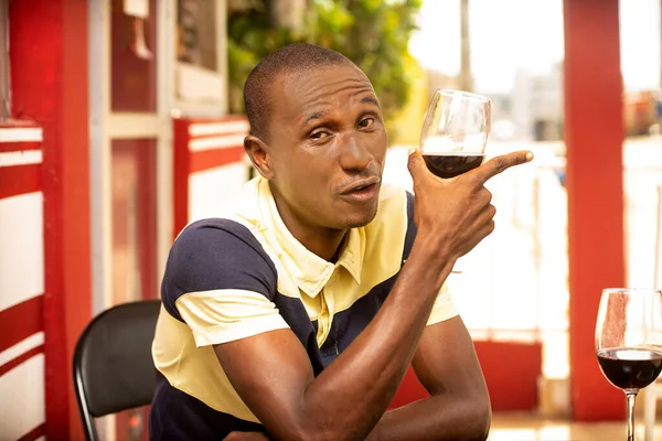 Jovem Bonito Segurando Copo Vinho Tinto Apontando Dedos Lado Olhando — Fotografia de Stock