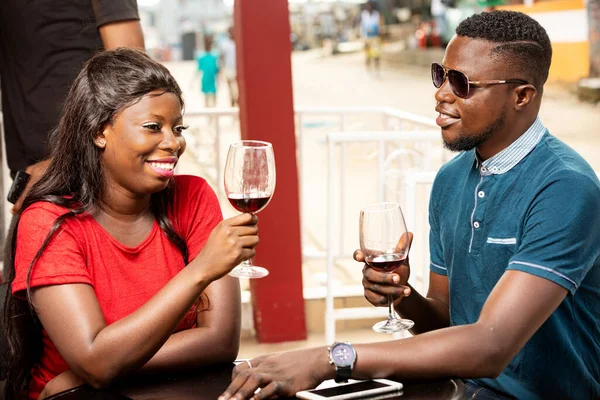 若いアフリカ人のカップルがワインのグラスを持って笑って — ストック写真