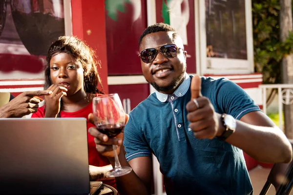 赤ワインを飲むレストランに座っている友人のグループの肖像画 サングラスをかけて親指でOkサインをする男 — ストック写真
