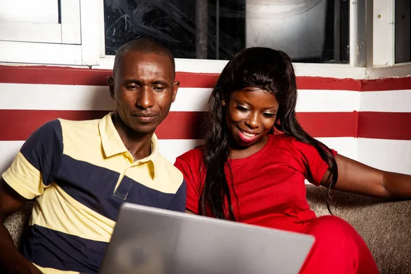 Красивая Молодая Африканская Пара Сидящая Помещении Работающая Ноутбуке Будучи Счастливой — стоковое фото