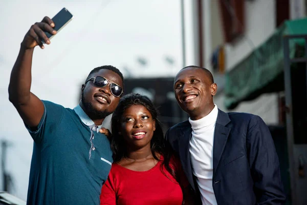 Group Young People Standing Outdoors Photographing Themselves Smiling Mobile Phone — Stock Photo, Image