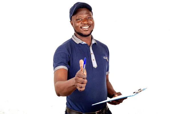 Young Delivery Man Standing Blue Uniform White Background Holding His — Stock Photo, Image