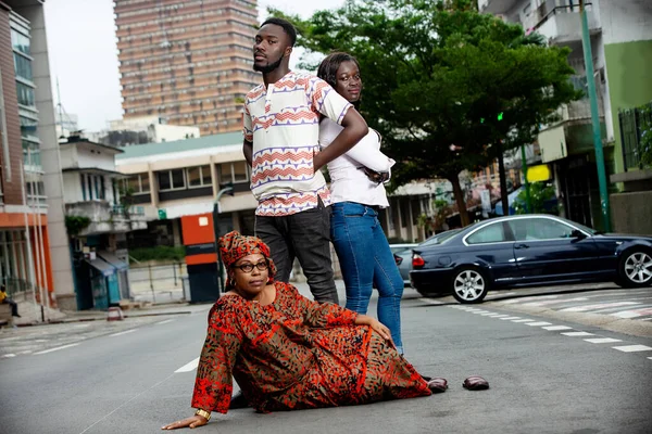 Genç Insan Sokakta Yan Yana Dururken Anneleri Yerde Oturup Kameraya — Stok fotoğraf