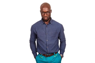 Yakışıklı, ciddi, gözlüklü, elini cebinde tutan genç bir adam. Stüdyoda, beyaz arka planda soyutlanmış.