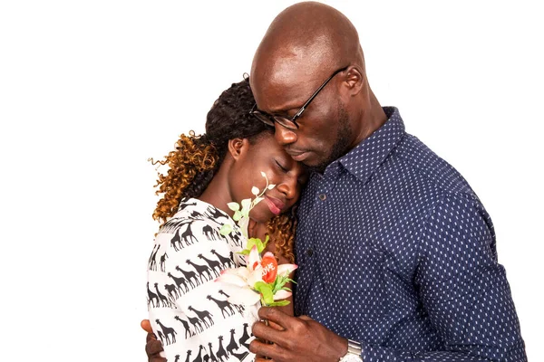 Beyaz bir arka planda duran güzel bir çift ellerinde bir çiçek, gülümsüyor.