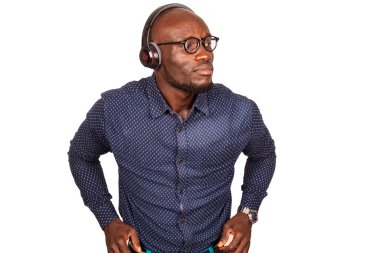 Genç adam kablosuz kulaklıkla müzik dinliyor ve müzik eşliğinde dans ediyor.