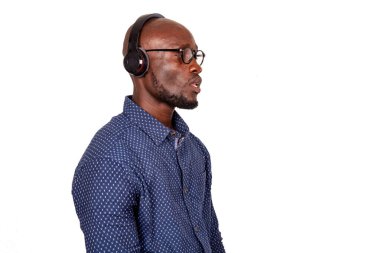 Gerçekten yakışıklı, gözlüklü ve kulaklıklı bir yetişkin adam yan bakıyor.