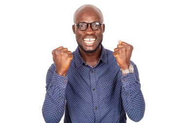 Beyaz arka planda gözlüklü yakışıklı işadamı kameraya kapalı yumruklarla gülüyor.