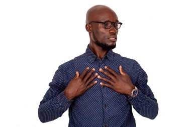 Beyaz arka planda duran yakışıklı bir adam gözlüğü. Elleri göğsünde yana bakıyor.